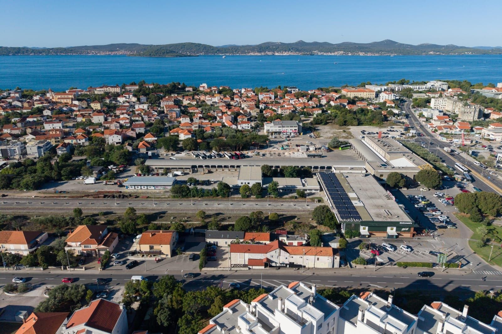 A coastal town with a marina, a large parking area, and a mix of residential and commercial buildings.