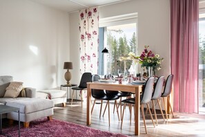 Un salon moderne comprenant un coin repas, un canapé, une table basse et une table à manger pour quatre personnes.
