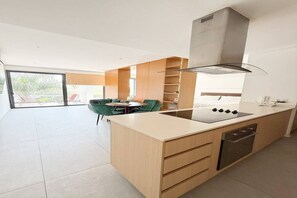 Una cucina moderna con isola centrale, mobili a scomparsa e un'ampia finestra.
