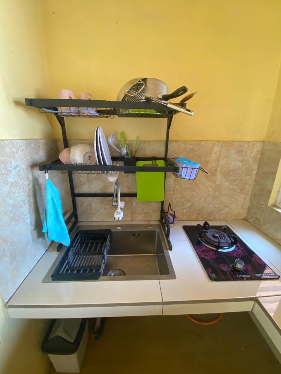 Cocina compacta con un lavabo, estufa y espacio para utensilios.