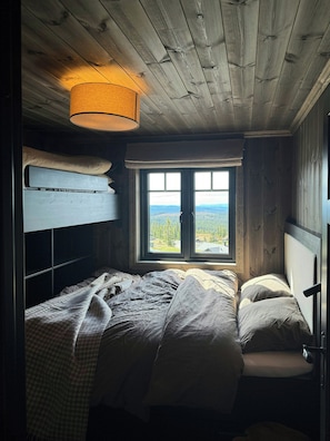 Ein Zimmer mit Etagenbett, einem Fenster mit Blick und einer Hängelampe.