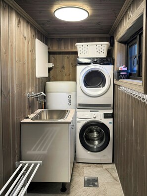A compact laundry room with a washing machine, dryer, and a sink. - Family cabin by the ski trails on Sjusjøen (Sjusjøen)