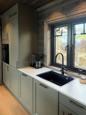 A kitchen with a built-in sink, a coffee maker, and a window with a view of the outdoors. - Family cabin by the ski trails on Sjusjøen (Sjusjøen)