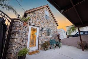 A stone house with a white door, a small porch, and a welcome mat. - Urban San Diego Retreat • Near Balboa Park + Beaches + Downtown | Casa Marlow (San Diego)