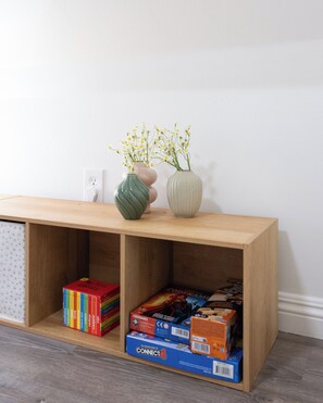 A wooden console table with a vase of flowers and a book collection. - Urban San Diego Retreat • Near Balboa Park + Beaches + Downtown | Casa Marlow (San Diego)
