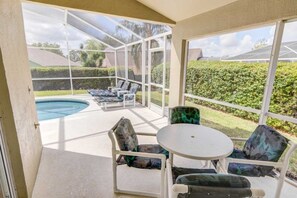 A covered patio with a pool, outdoor seating, and a view of the backyard. - Southern Dunes Comforts Of Home! Golf Views! 4 Bedroom Home (Haines City)