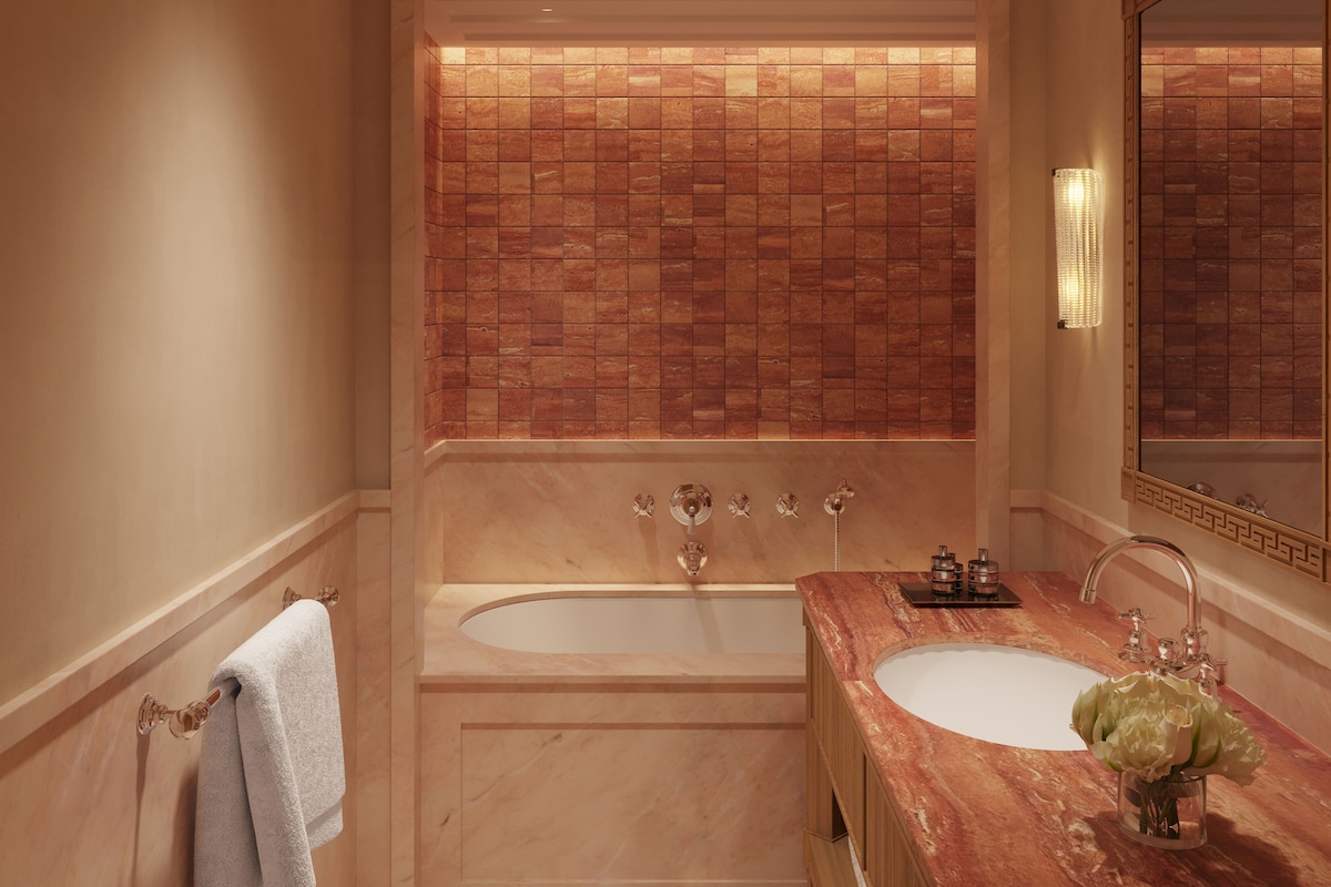 A bathroom with a double sink, a bathtub, and a large mirror.