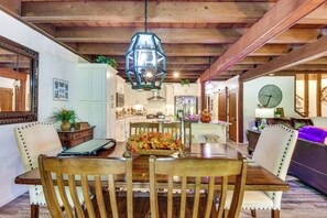 Un espace repas avec une table en bois, des chaises et une lanterne suspendue.