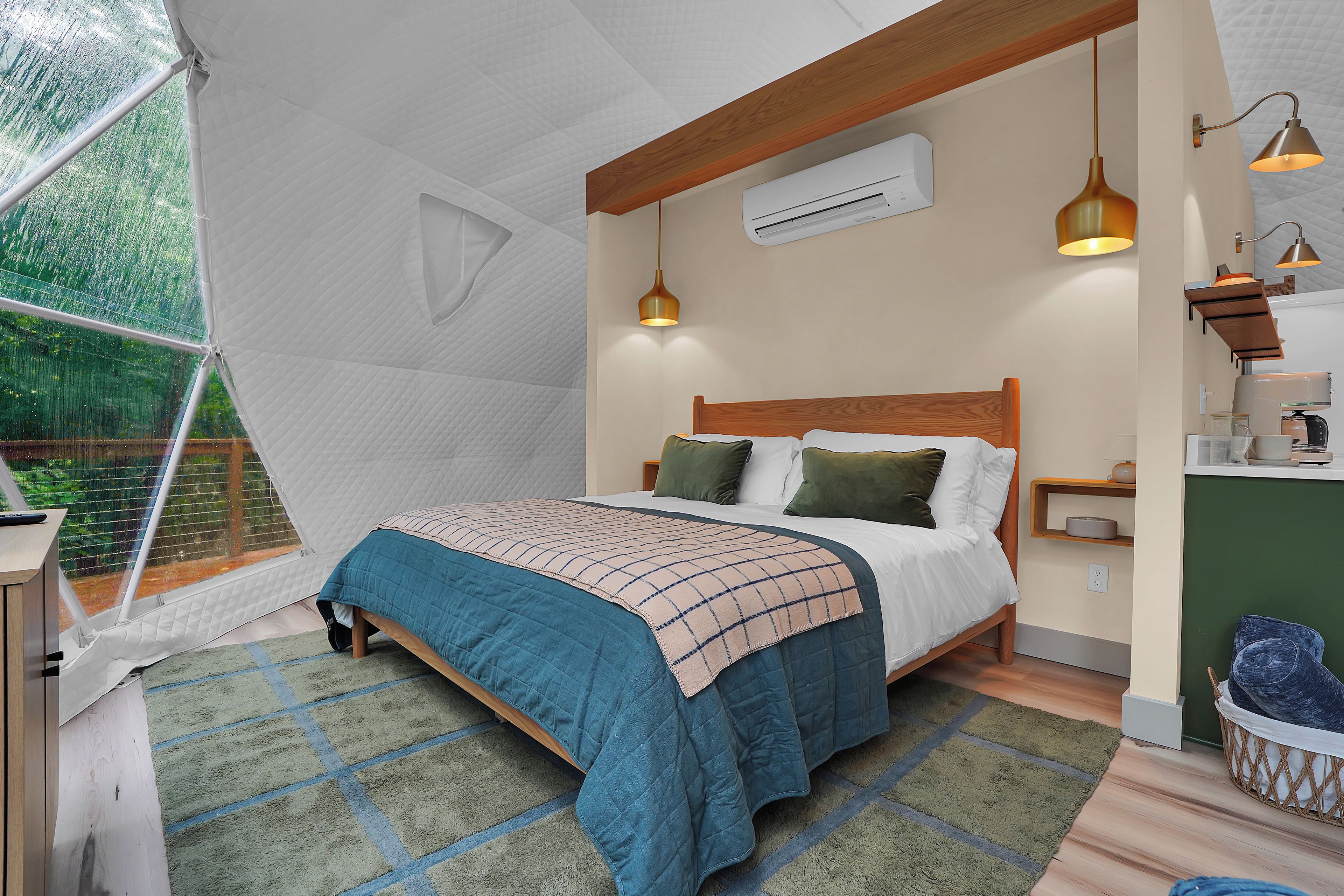 A tent-style room with a bed, a small table, and a hanging light fixture.
