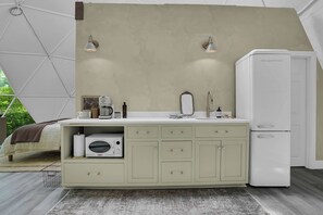 Una cocina americana con refrigerador blanco, un lavamanos y una cafetera.