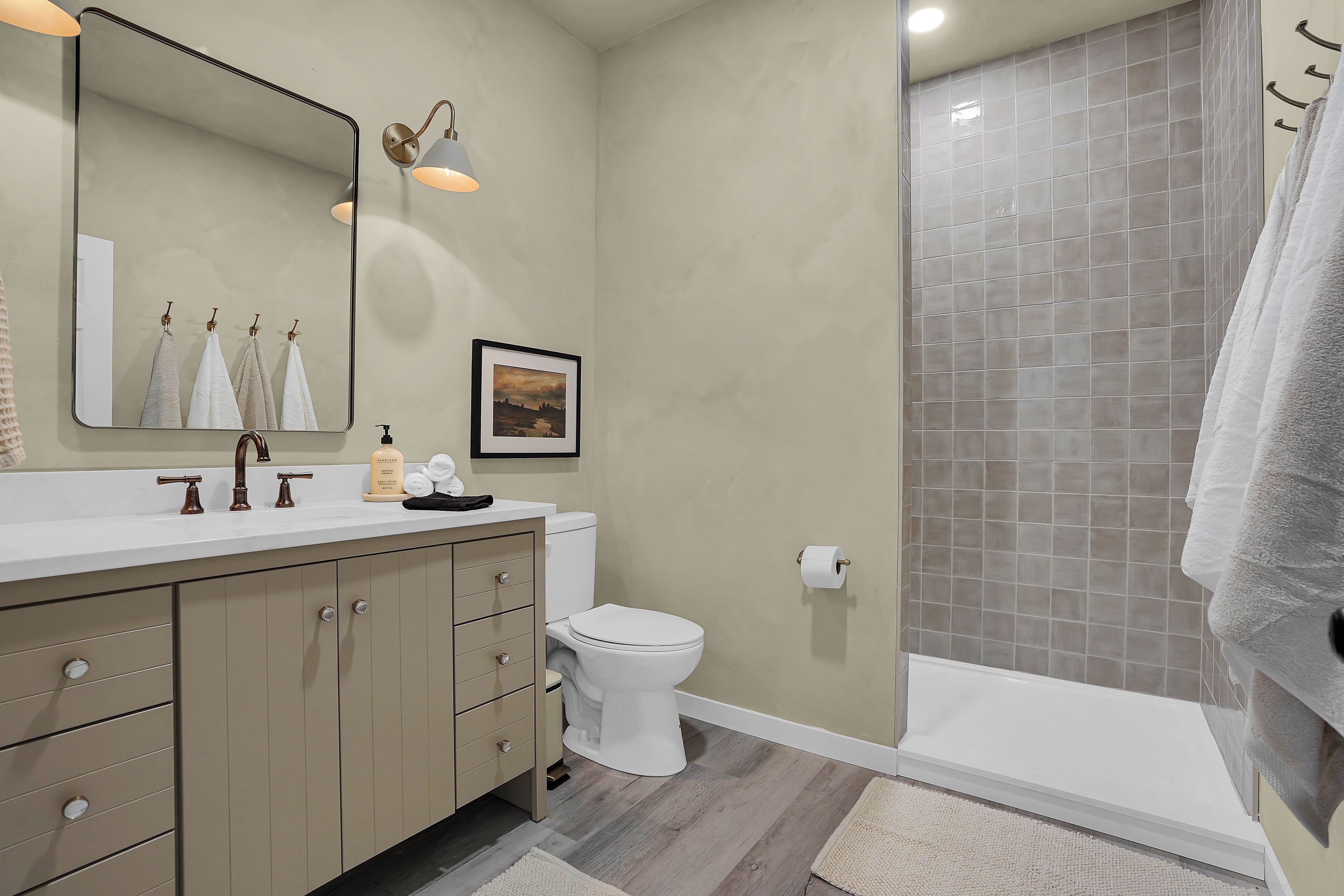 Ein Badezimmer mit Toilette, Waschbecken, Waschtisch und Duschbereich.