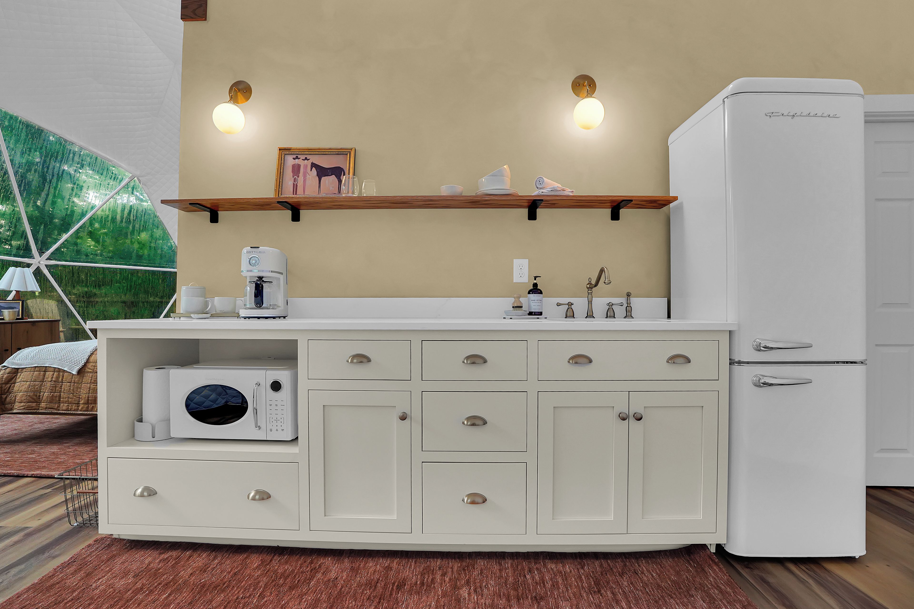 A compact kitchenette with a built-in microwave, a coffee maker, and a refrigerator.
