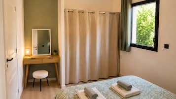 Ein Schlafzimmer mit einem Bett, einem Nachttisch, einem Spiegel, einem Fenster mit Vorhängen und einer Tür.
