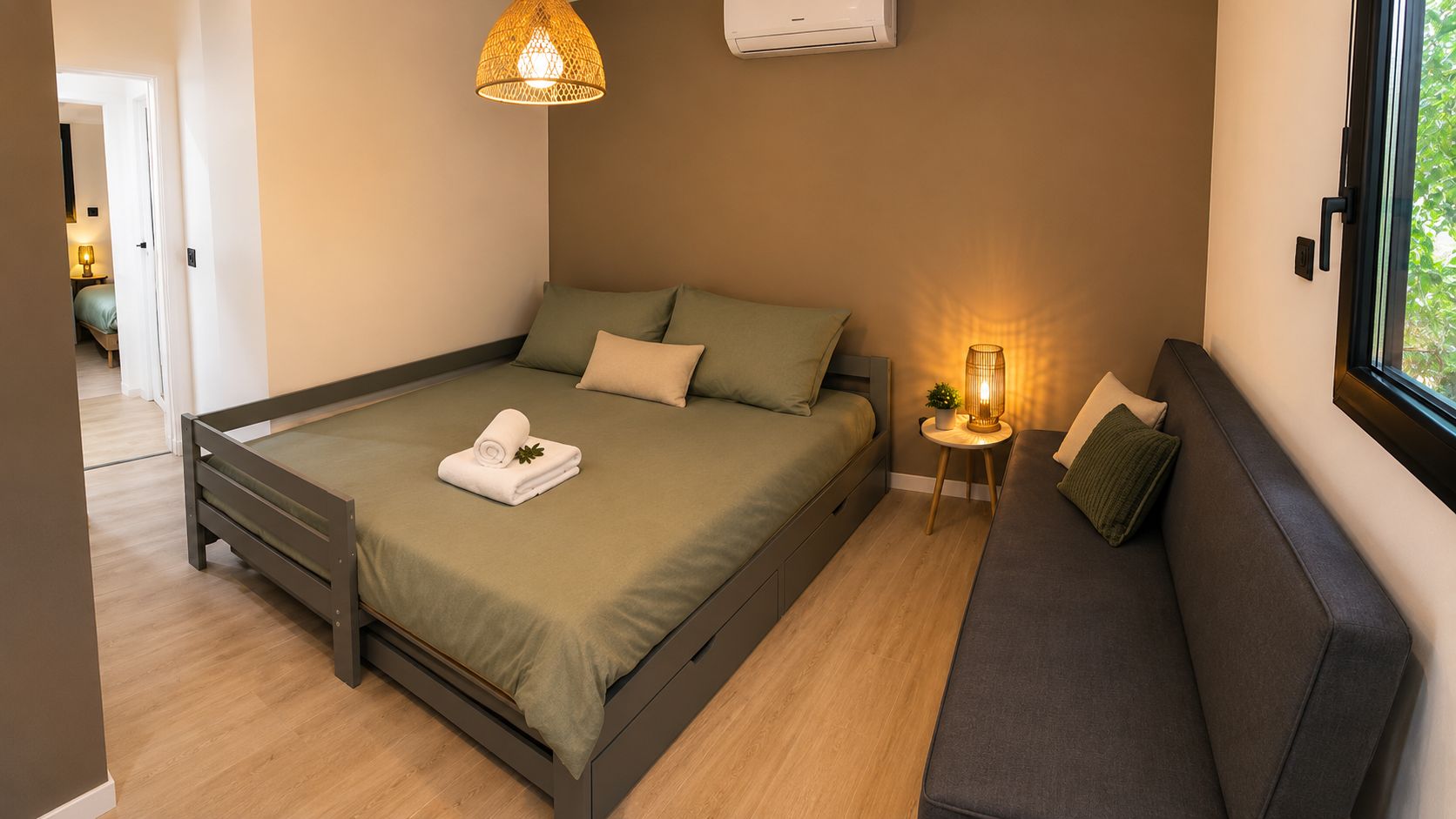 Een moderne slaapkamer met een bed, nachtkastje, lamp en uitzicht op het omliggende landschap.
