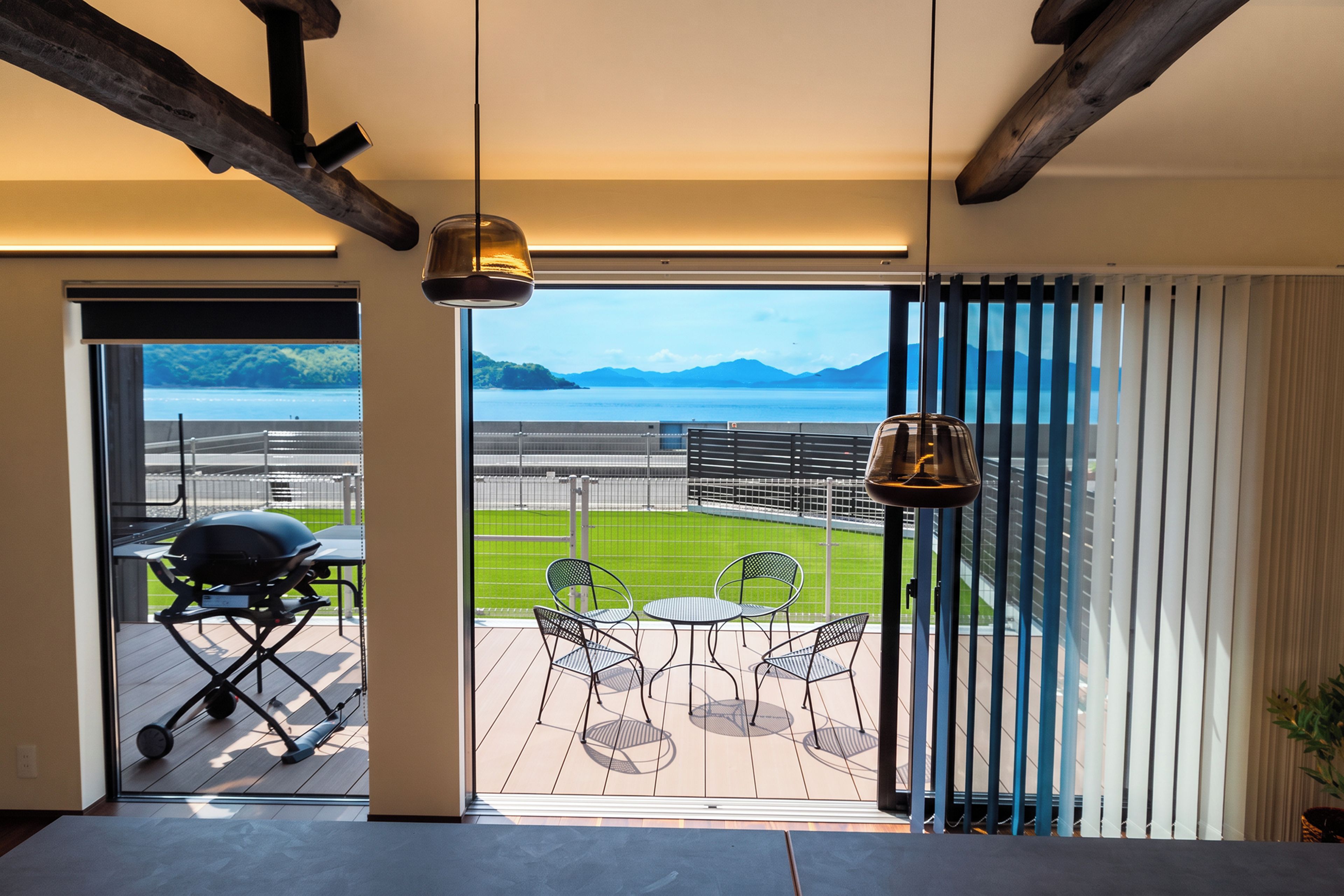 A modern interior with a view of a sports field and mountains.