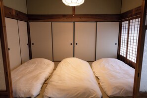 Ein traditioneller japanischer Raum mit Tatami-Bodenbelag, Shoji-Schirm und Deckenleuchte.