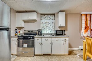 A compact kitchen with a stove, microwave, and a coffee maker. - Work, Play & Explore! Saugus Extended Stay (Saugus)
