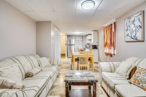 A living room with two sofas, a coffee table, and a dining area with a table and chairs. - Work, Play & Explore! Saugus Extended Stay (Saugus)