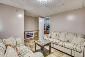A living room with a sofa, a coffee table, and a television displaying a Samsung advertisement. - Work, Play & Explore! Saugus Extended Stay (Saugus)