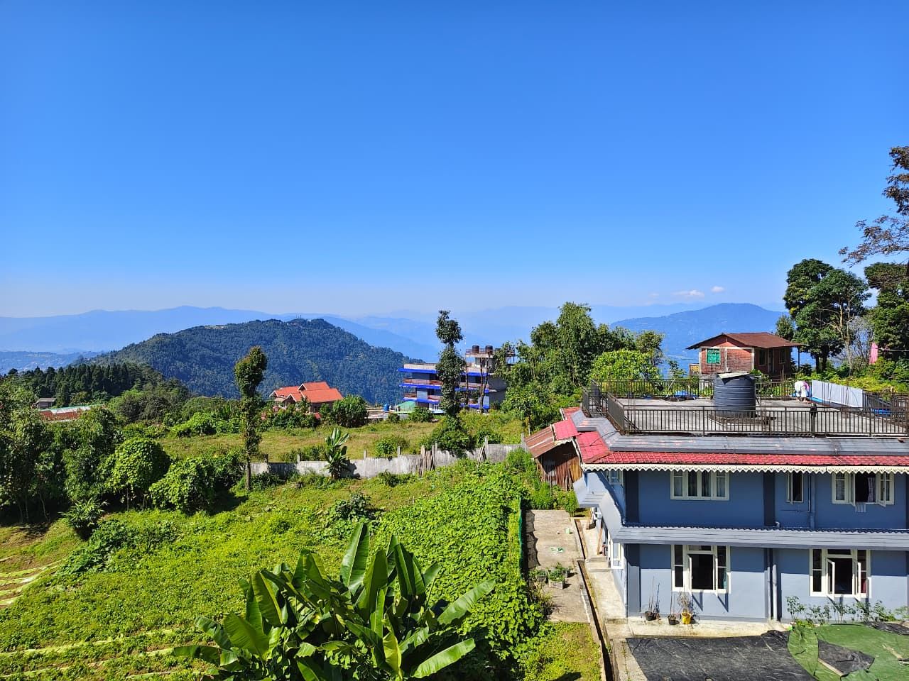A residential area with houses, a view of mountains, and a clear sky.