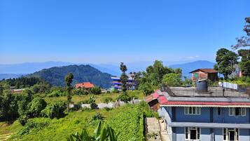 A residential area with houses, a view of mountains, and a clear sky.