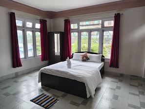A bedroom with a bed, a window, and a door.