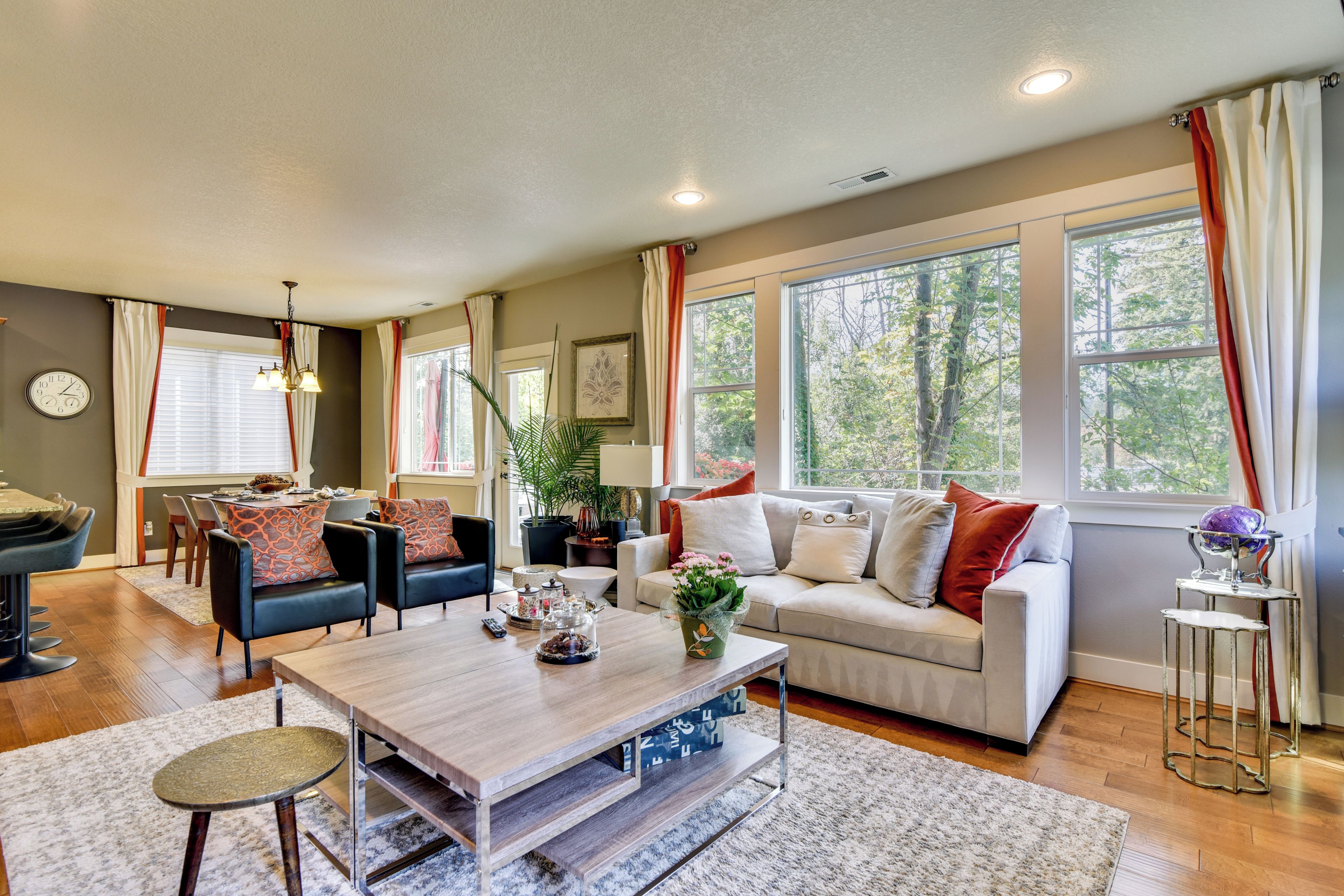 A modern living room with a sofa, coffee table, and dining area.
