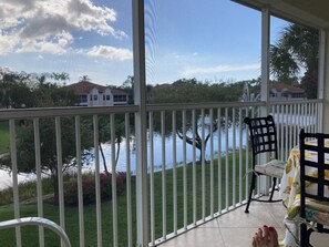 Un balcon donnant sur un lac, avec une chaise et une table.