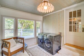 A laundry room with a wooden bench, a washing machine, and a large window with a view of a tree. - Great for Families! Egg Harbor Gem w/ Beach Access (Egg Harbor)