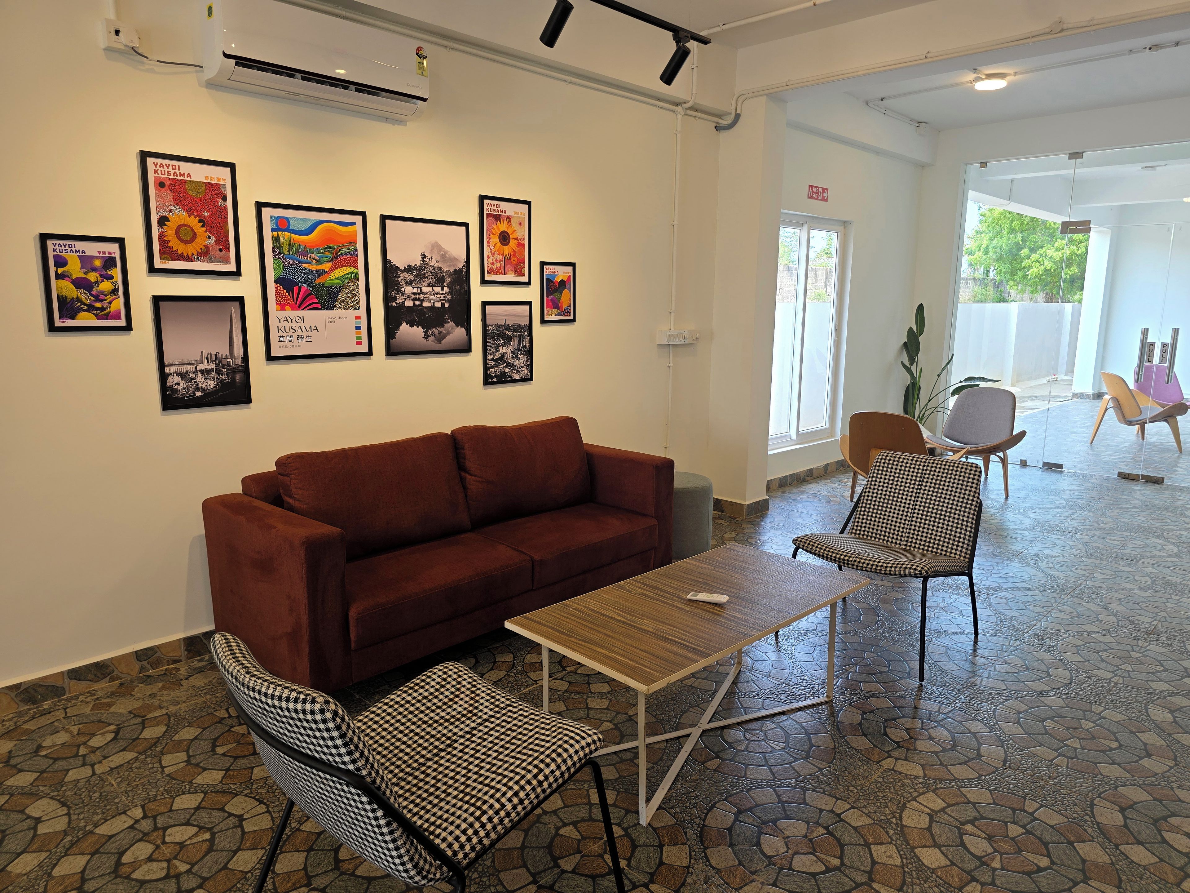 A modern interior with a brown sofa, checkered chairs, a small table, and artwork on the walls.