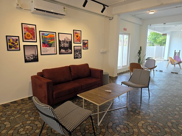 A modern interior with a brown sofa, checkered chairs, a small table, and artwork on the walls.