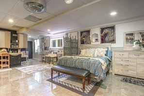 A spacious bedroom with a large bed, a desk, and a dining area. - Chicago South Side Studio w/ Gated Parking (Chicago)