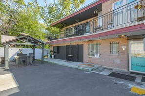A two-story building with a balcony, a covered outdoor seating area, and a storefront with a sign. - Chicago South Side Studio w/ Gated Parking (Chicago)