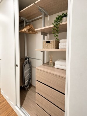 Ein begehbarer Kleiderschrank mit Holzböden, Ablageflächen und Schubladen.