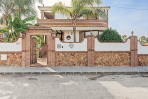 Une maison à deux étages avec un mur en pierre, un portail en bois et une plaque indiquant « Villa Arandel, n° 30 ».