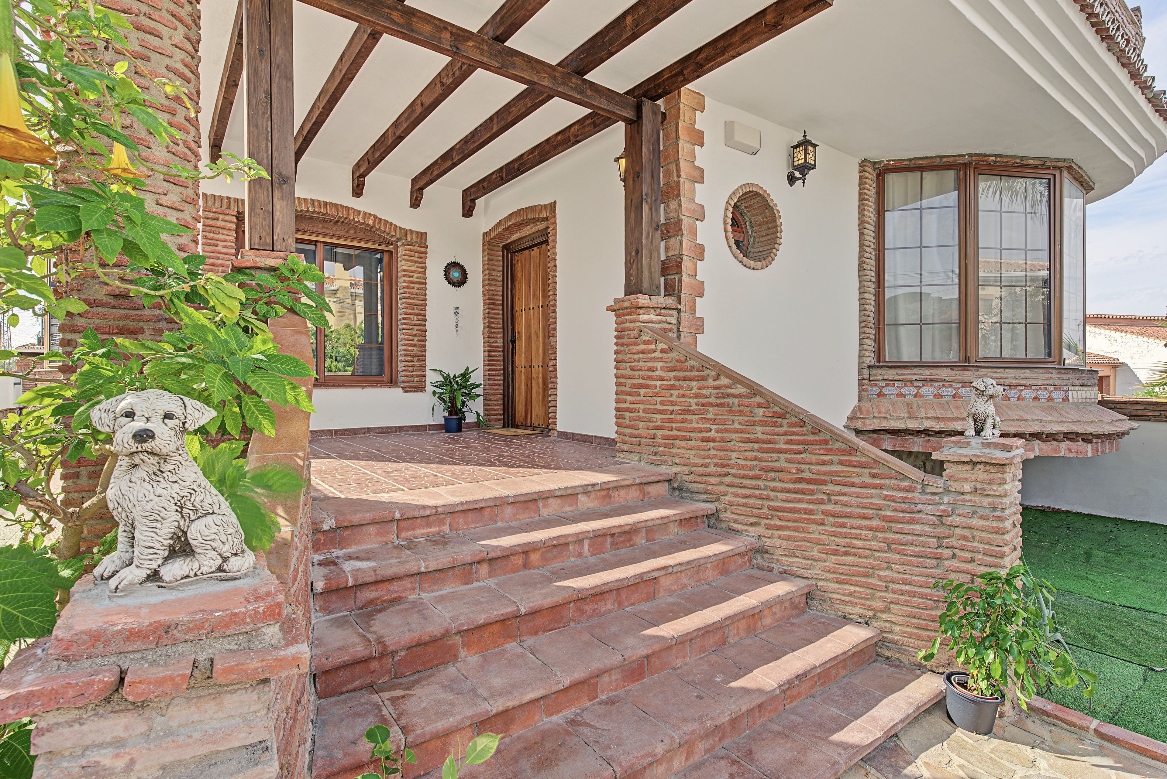 A building with a brick exterior, wooden beams, and a staircase leading to a door.