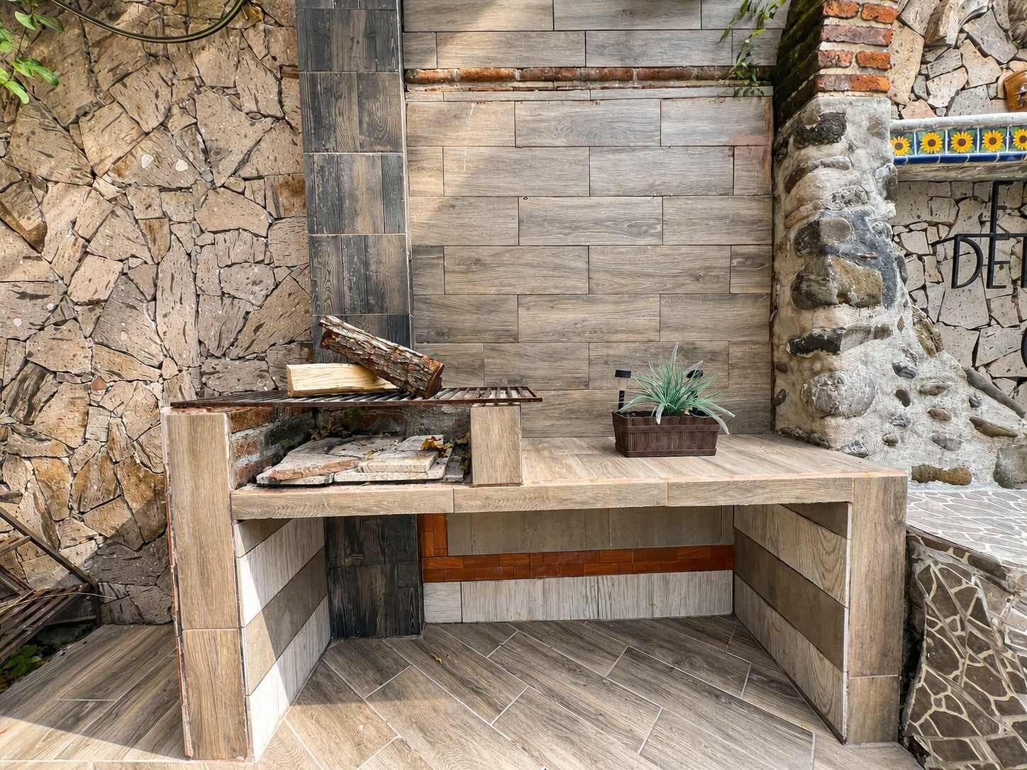 A corner seating area with a stone wall, a built-in bench, and a small potted plant.