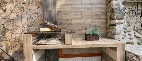 A corner seating area with a stone wall, a built-in bench, and a small potted plant.
