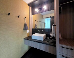 A modern bathroom with a large mirror, a white sink, and a towel rack. - Semi-Private Patio Facing Pool + Firepit | Mtn Views | Garden King at Mahala (Palm Springs)