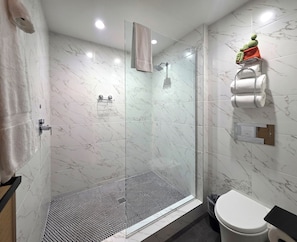 A modern bathroom with a glass-enclosed shower, a toilet, and a sink. - Pool + Spa + Firepit + Courtyard | Mtn Views | Desert King at Mahala (Palm Springs)