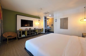 A hotel room with a large bed, a desk with a flat-screen TV, a chair, and a wardrobe. - Pool + Spa + Firepit + Courtyard | Mtn Views | Desert King at Mahala (Palm Springs)