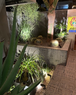 Illuminated desert landscaping and colorful tilework create a warm evening welcome. - Pool + Spa + Firepit + Courtyard | Mtn Views | Desert King at Mahala (Palm Springs)