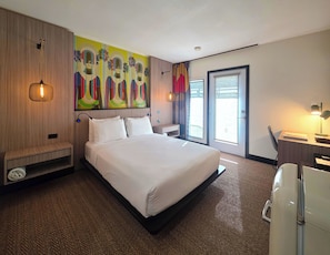 A hotel room with a large bed, a desk with a chair, a small seating area, and a large window with a view. - Pool + Spa + Firepit + Courtyard | Mtn Views | Sun Queen at Mahala (Palm Springs)