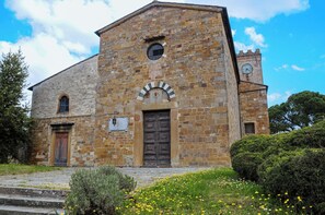 Un edifici de pedra històric amb una torre de l'ajuntament, una entrada central en arc i una torre campanar.