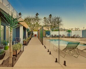 Poolside relaxation with palm trees, lounge seating, and bright desert-sky views. - Pool + Spa + Firepit + Courtyard | Mtn Views | Sun Queen at Mahala (Palm Springs)