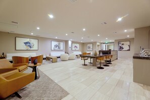 A spacious lobby with a reception desk, seating area, and artwork on the walls. - Walkable & Sleek LA Condo w/ Private Office (Los Angeles)