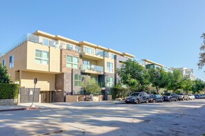 Ein mehrstöckiges Wohngebäude mit modernem architektonischen Design, das Balkone und große Fenster aufweist.
