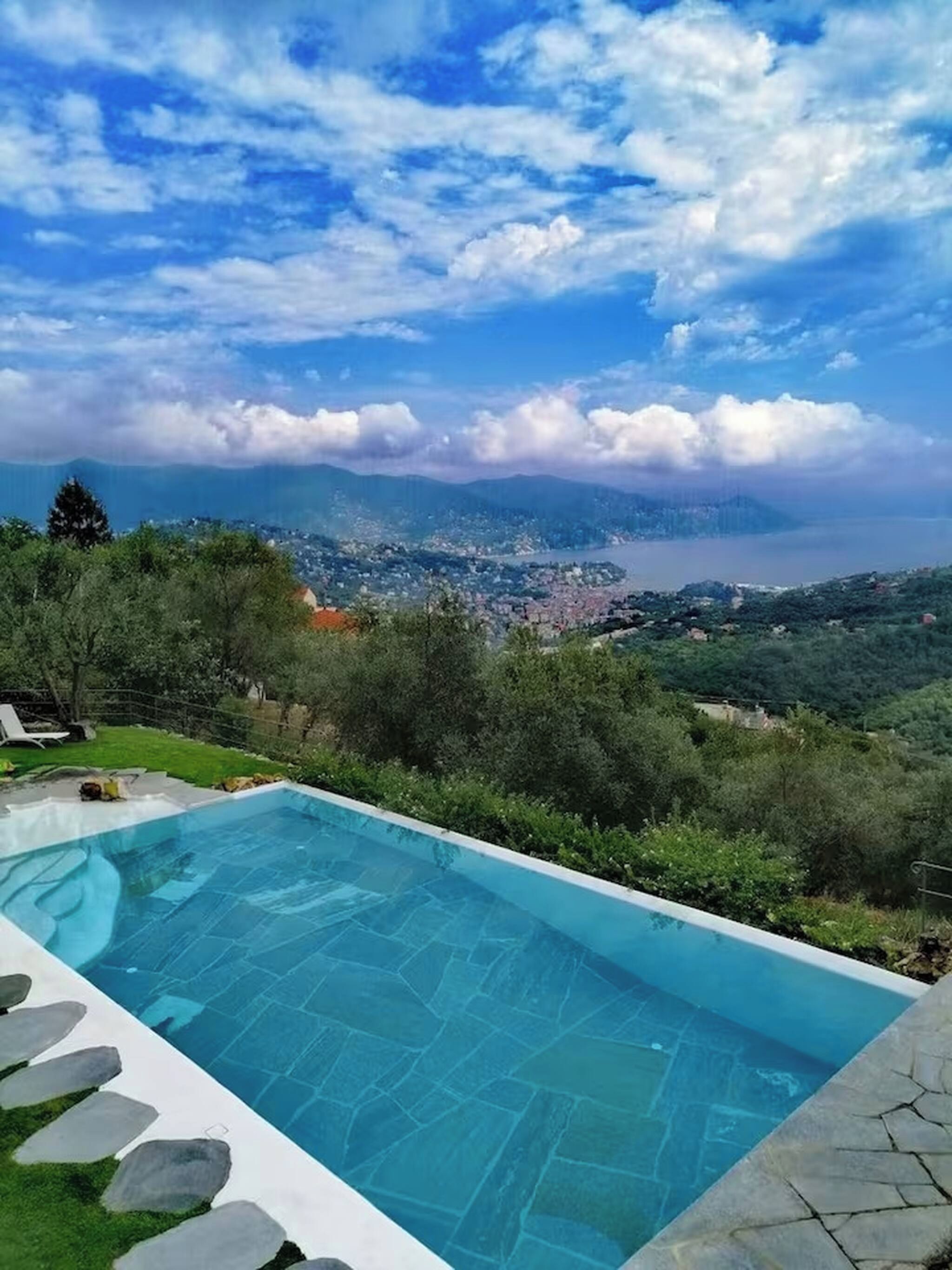 Une piscine offrant une vue sur la ville et les montagnes au loin.