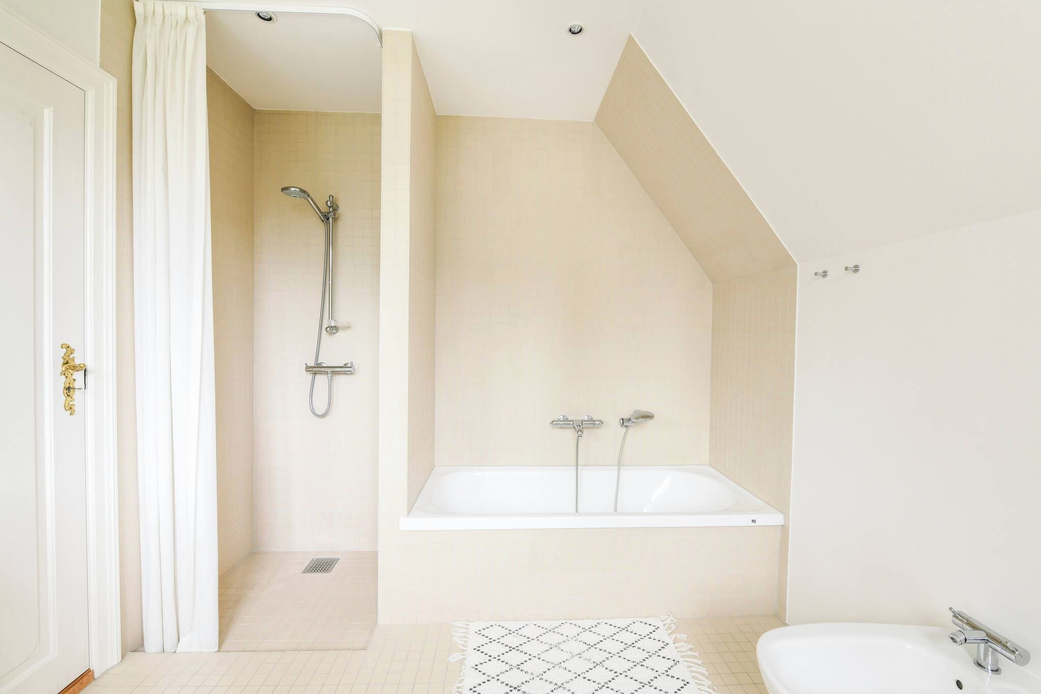 A modern bathroom with a shower, bathtub, and a sink.