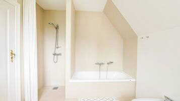 A modern bathroom with a shower, bathtub, and a sink.